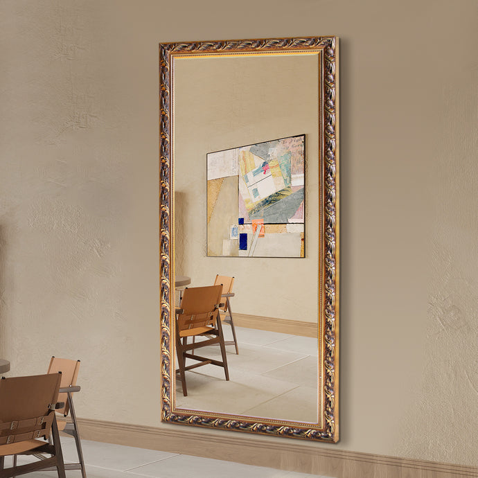 Decorative mirror with ornate frame on a wall above a table and chairs