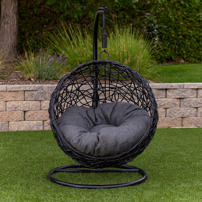 Black wicker egg chair with gray cushion on grass